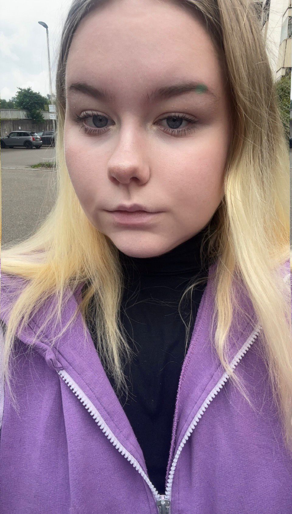 Person wearing purple hoodie outdoors.